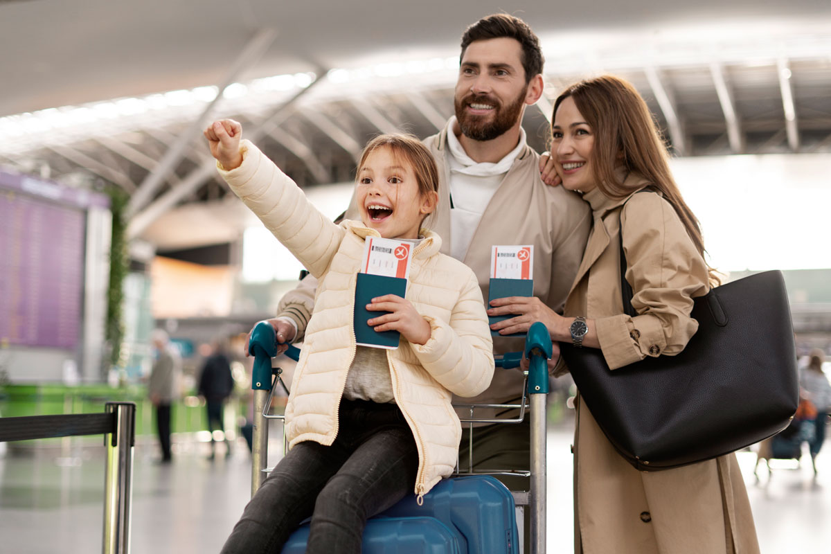 Una familia feliz recorriendo un aeropuerto con sus pasaportes y boletos en mano