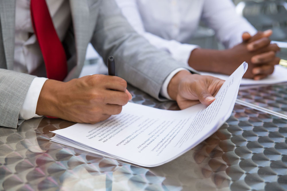 Persona firmando unos documentos importantes